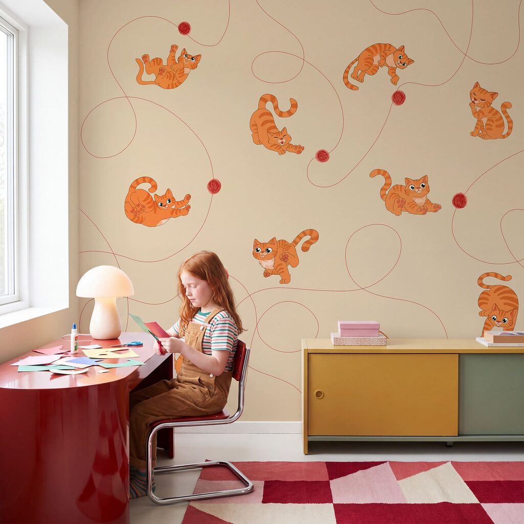 Kätzchen mit roten Wollknäueln in einem Interieur
