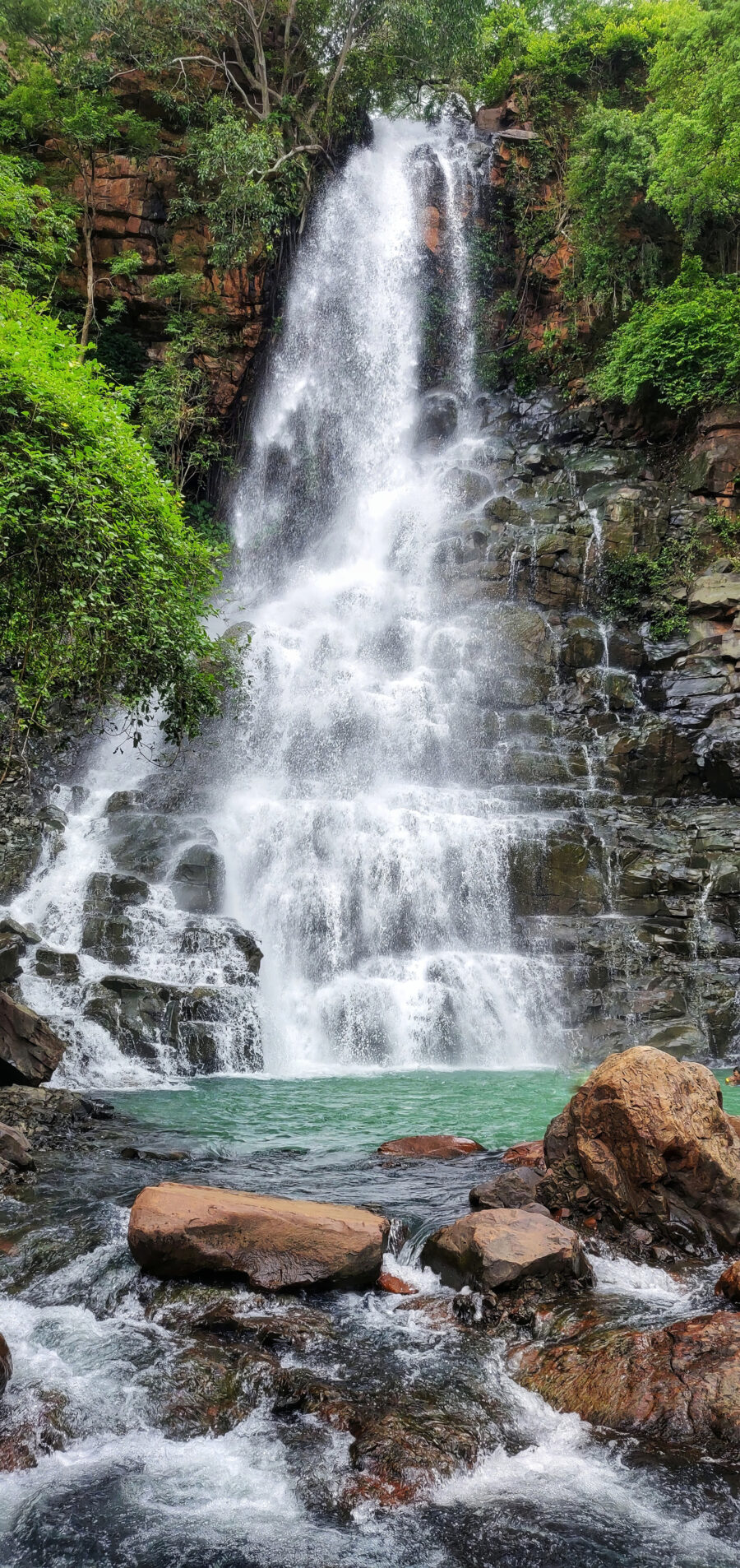 Wasserfall zwischen dunklen Felsen — ganzes Design